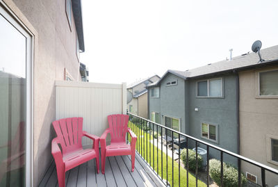 Empty chairs outside house against clear sky