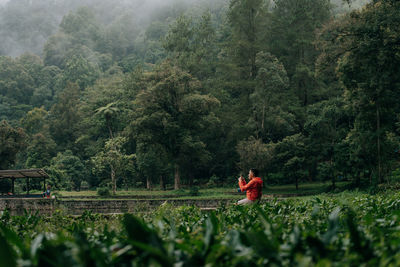 Rear view of woman walking on field