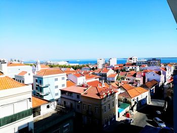 High angle view of townscape by sea against clear sky