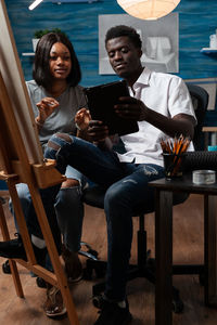 Young woman using laptop while sitting on chair at home