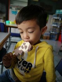 Cute boy eating flavored ice at restaurant