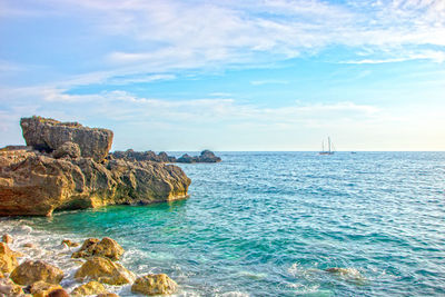 Scenic view of rocks in sea against sky