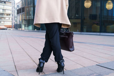 Low section of woman walking on footpath