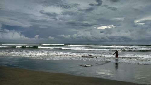 Man standing on beach against sky