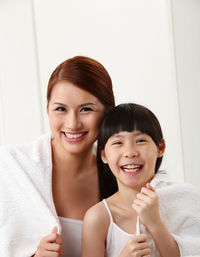 Portrait of smiling mother and daughter at home