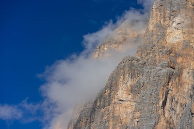 Low angle view of rocky mountains in tofana di rozes against sky
