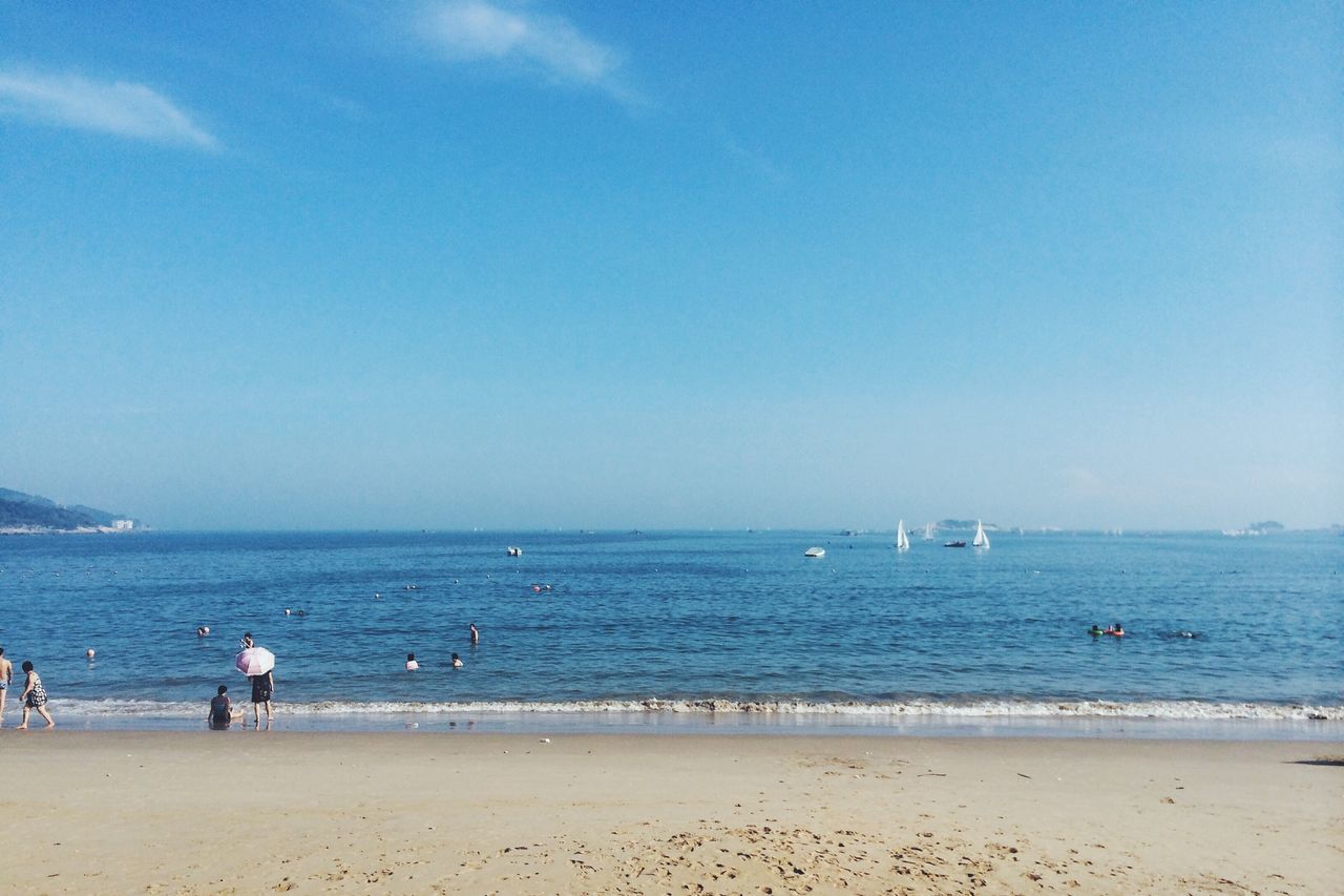 sea, beach, water, horizon over water, shore, sand, blue, vacations, copy space, scenics, leisure activity, beauty in nature, tranquility, large group of people, lifestyles, tranquil scene, clear sky, sky, nature