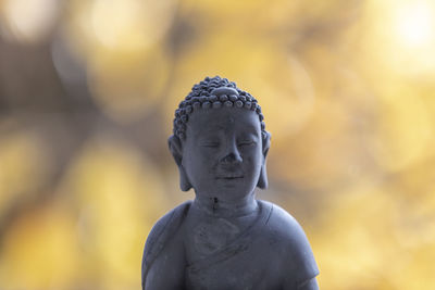 Close-up of buddha statue against blurred background
