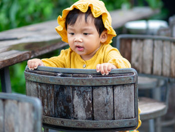 Portrait of young woman standing by fence