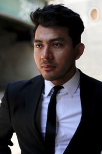 Young man wearing suit while standing outdoors