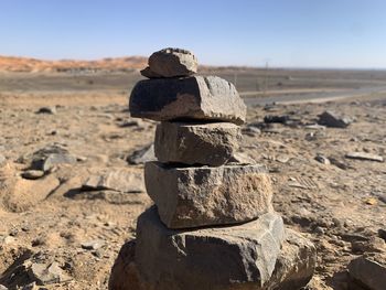 Stack of rocks on land against sky