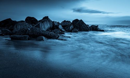 Rocks in sea against sky