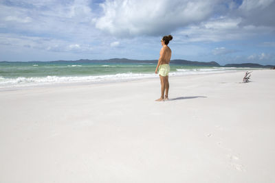 Full length of man standing on beach against sky