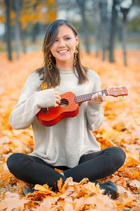 Portrait of young woman holding autumn leaves