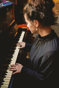 Side view of woman playing piano