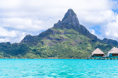 Scenic view of sea and mountains against sky