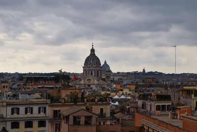 View of buildings in city against cloudy sky