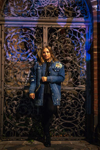 Fashionable young woman in city at night