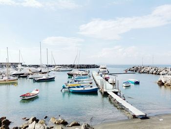 Boats moored in calm sea against sky