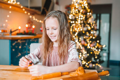 Portrait of girl with illuminated christmas tree