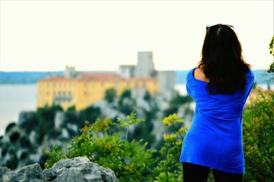 Rear view of woman standing against plants