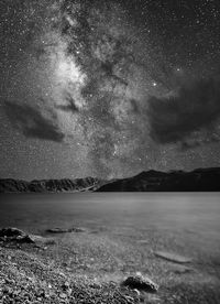 Scenic view of lake against sky at night