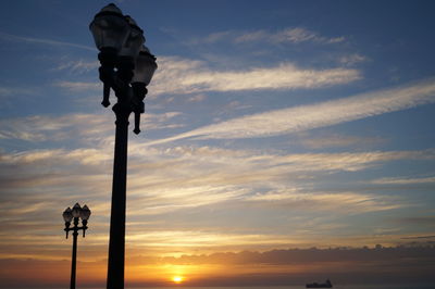 Low angle view of silhouette cross against sky during sunset
