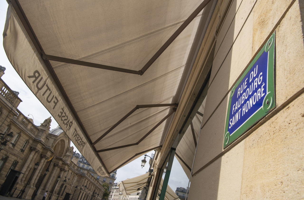 LOW ANGLE VIEW OF TEXT ON WALL AGAINST BUILDING