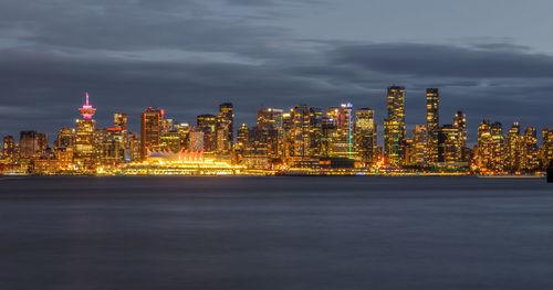 Illuminated buildings in city against sky