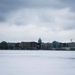 Buildings in city against cloudy sky