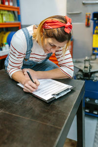 Woman checking stock products of mechanic garage