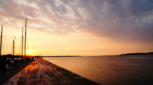 Scenic view of sea against cloudy sky at sunset