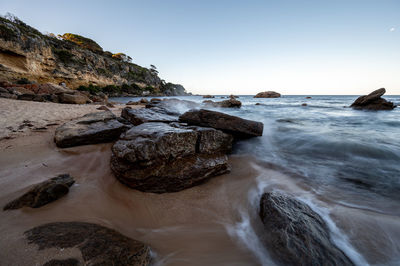 Scenic view of rocks in sea against sky