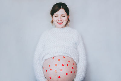 Portrait of smiling woman against white background