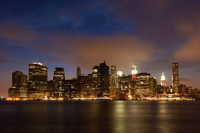 Illuminated buildings in city against sky at night