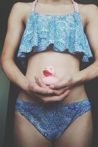 Midsection of woman holding heart shape