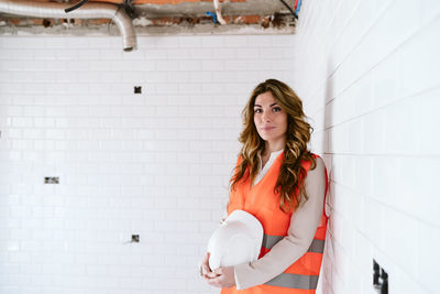 Inspector or architect professional woman holding helmet checking kitchen at construction site