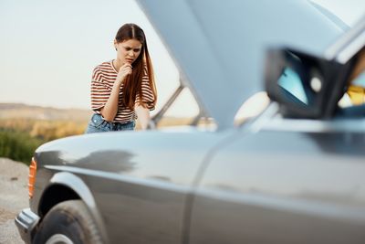 Side view of woman holding car