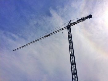 Low angle view of crane against sky