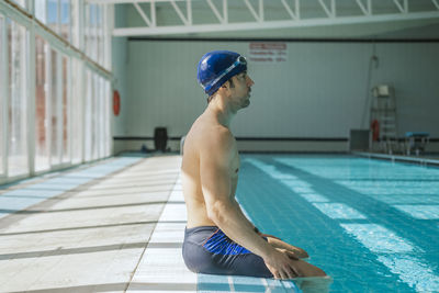 Portrait of young man standing in swimming pool