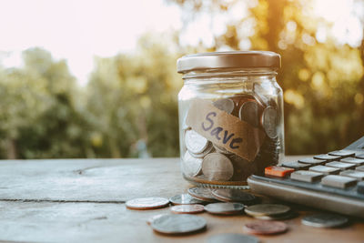 Close-up of coins in jar on table