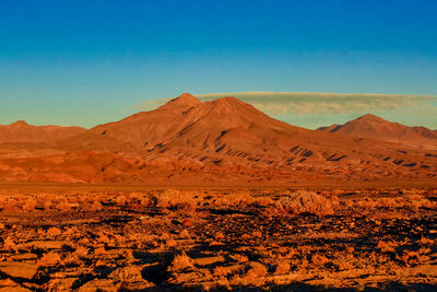 Scenic view of desert against clear blue sky