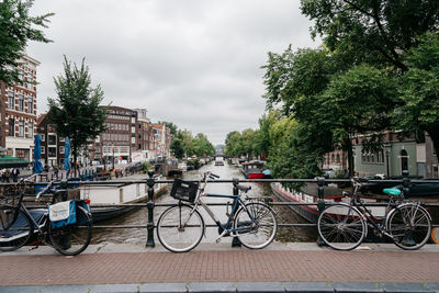 Bicycles on sidewalk in city against sky