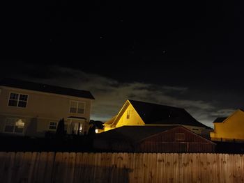 Low angle view of yellow buildings against sky at night