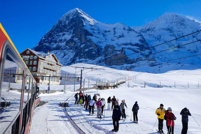 People skiing on snow covered landscape