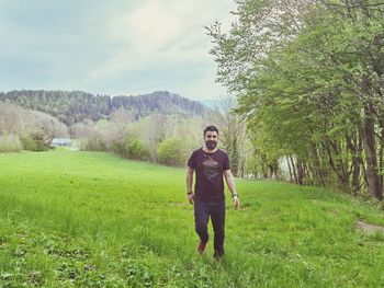 Full length portrait of man standing on field