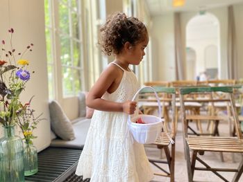 Side view of girl standing next to table at a wedding 