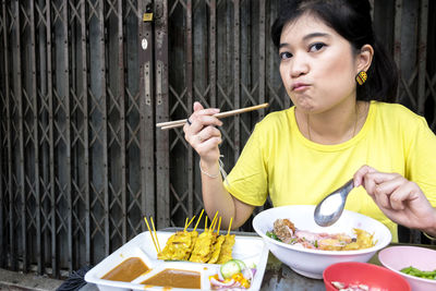 Portrait of woman eating street food outdoors