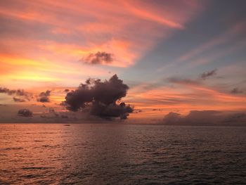 Scenic view of sea against dramatic sky during sunset