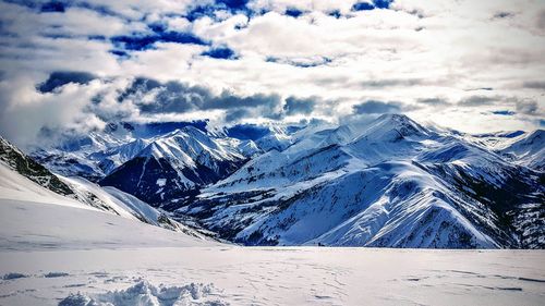 Aerial view of snowcapped mountains against sky